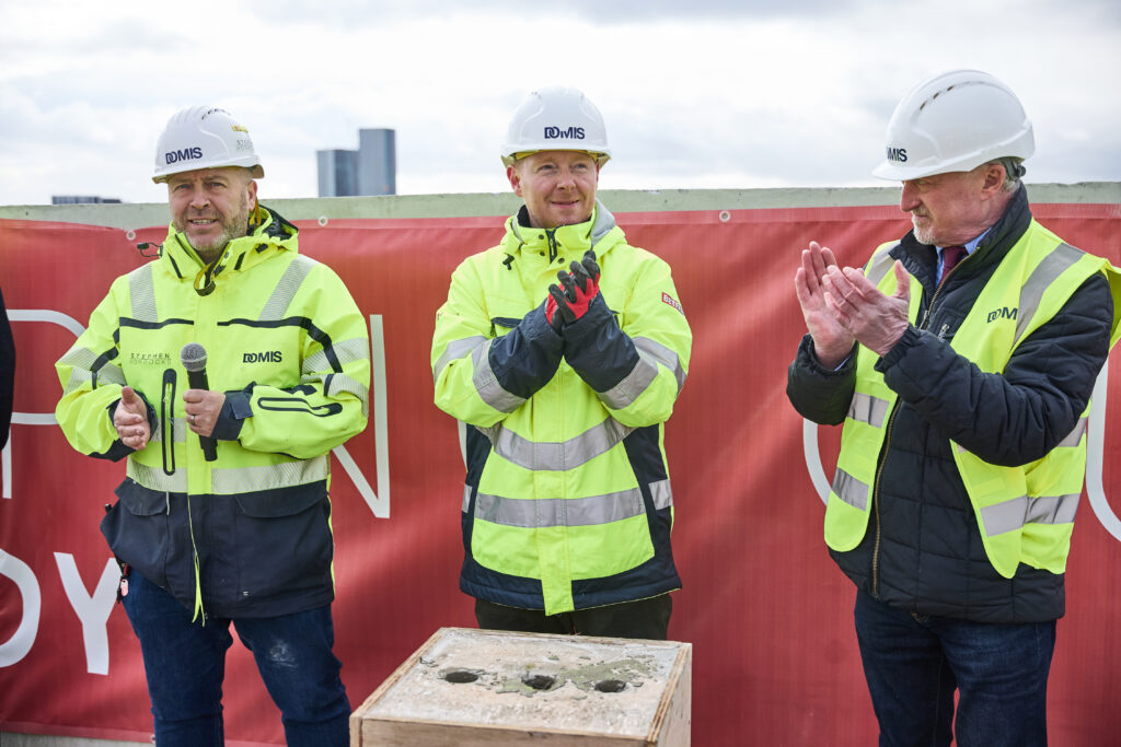 Construction workers in high-visibility gear clapping.