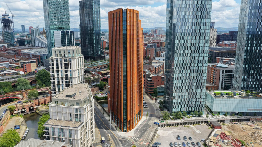Tall orange skyscraper surrounded by modern buildings.